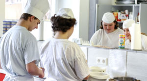 Apprentices in the kitchen preparing a meal