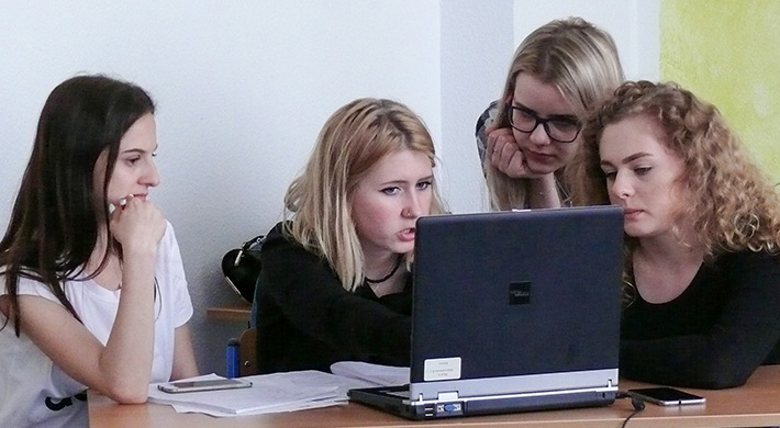 4 female students analysing their company data during the business simulation game